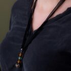 Pendentif Ruban de soie et perles de verre porté sur une tenue noire.